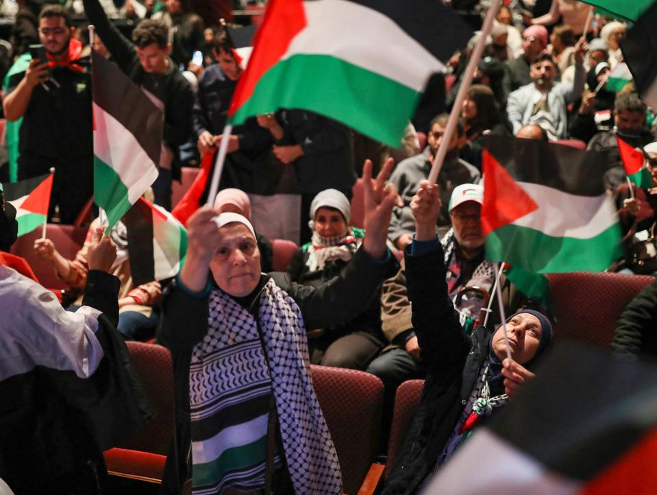Supporters of “Free Free Palestine” wave Palestinian flags during the community rally in support of freeing Palestine at Ford Community & Performing Arts Center in Dearborn on Tuesday, Oct. 10, 2023. Hamas militants attacked Israel on Saturday, killing more than 900 people, including at least 14 Americans. Israel has responded with a siege and heavy bombing of the Gaza Strip resulting in over 1500 deaths total.
