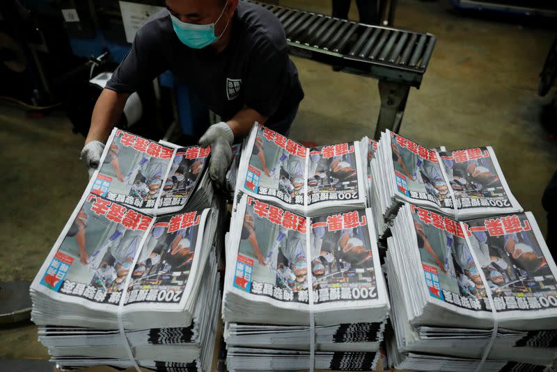 Bundles of the Apple Daily newspaper, published by Next Media Ltd, with a headline "Apple Daily will fight on" are seen at the company's printing facility in Hong Kong