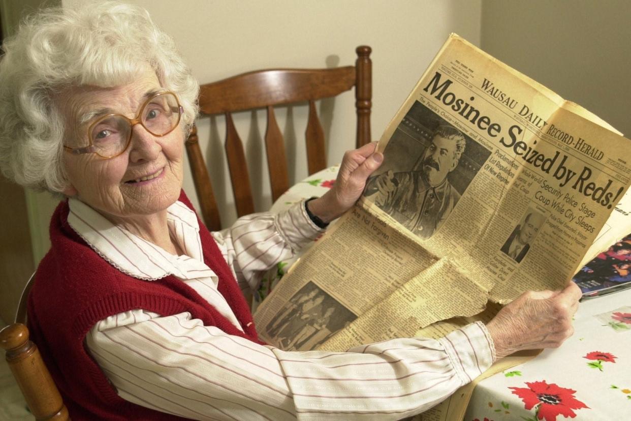 Grace O'Connor, a former Mosinee teacher and librarian, holds a Wausau newspaper that covered the Mosinee May Day event held in 1950. O'Connor posed for the photo in 2000, when the Wausau Daily Herald did a story on the 50th anniversary of the event.