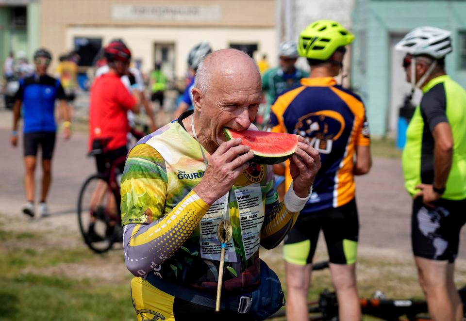 Ken Blue of Oswego, Illinois, enjoys a slice of watermelon after rolling into Quimby during RAGBRAI.