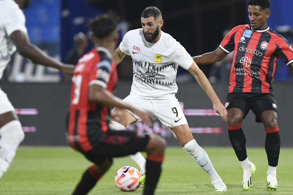 FILE - Al Ittihad's Karim Benzema, center, fights for the ball during his team match against Al Raed in Saudi Professional League, in Buraidah, Saudi Arabia, Monday, Aug. 14, 2023. Cristiano Ronaldo, Neymar and Karim Benzema have won a combined total of 11 UEFA Champions League titles and, starting Monday, Sept. 18, 2023, they lead the Saudi Arabian challenge in the Asian edition.(AP Photo/File)