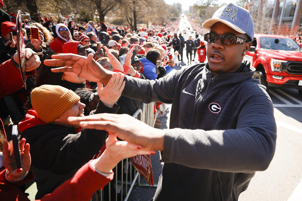 Georgia defensive lineman Warren Brinson greets fans during a parade celebrating the Bulldog's second consecutive NCAA college football national championship, Saturday, Jan. 14, 2023, in Athens, Ga. (AP Photo/Alex Slitz)