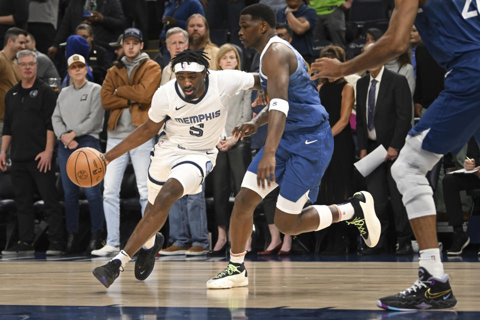 Memphis Grizzlies forward Vince Williams Jr., left, drives past Minnesota Timberwolves guard Anthony Edwards during the first half of an NBA basketball game Wednesday, Feb 28, 2024, in Minneapolis. (AP Photo/Craig Lassig)