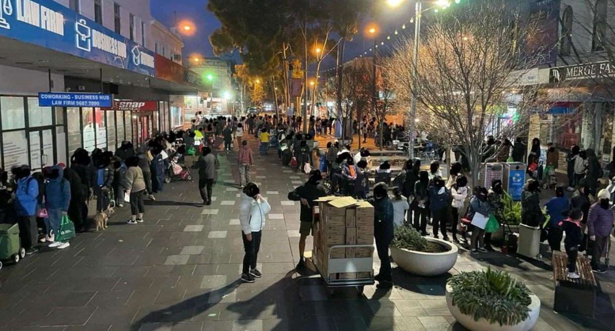 Crowds of people lined up for a charity food service in Melbourne's inner city.