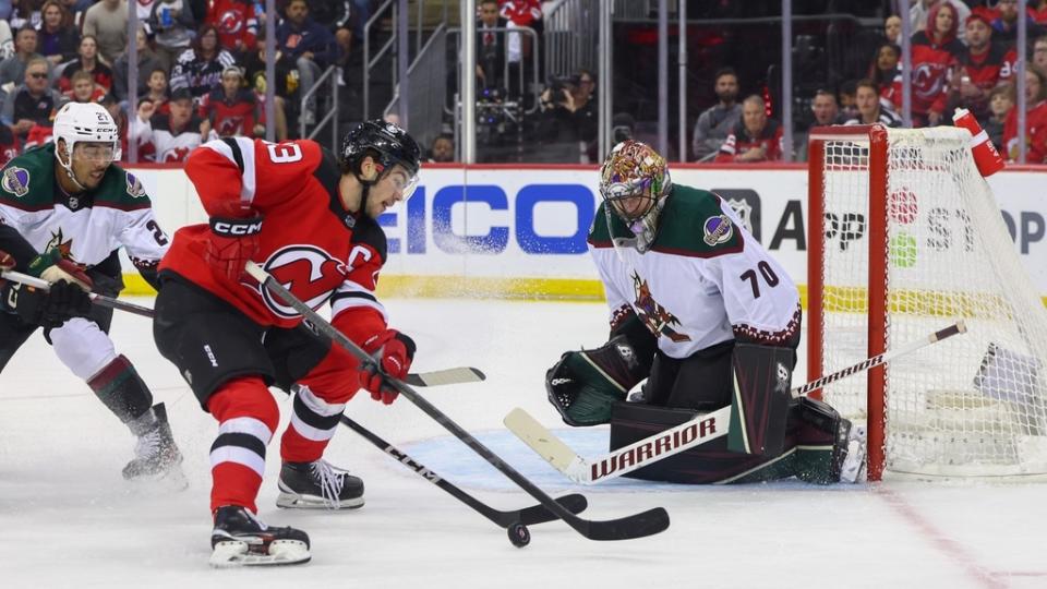 Oct 13, 2023; Newark, New Jersey, USA; Arizona Coyotes goaltender Karel Vejmelka (70) defends his net against New Jersey Devils center Nico Hischier (13) during the second period at Prudential Center.