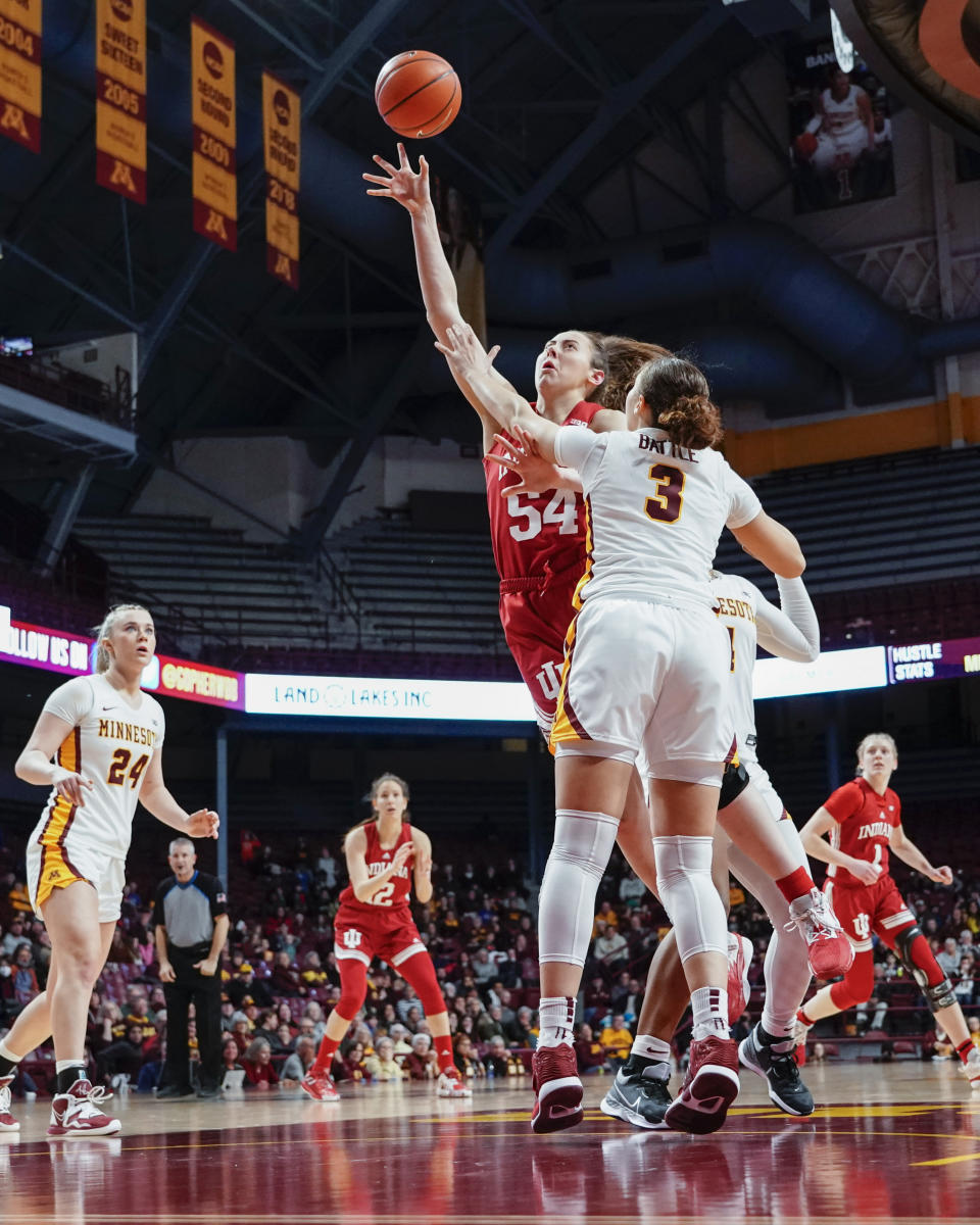 Indiana forward Mackenzie Holmes (54) goes up for a shot past Minnesota guard Amaya Battle (3) during the second half of an NCAA college basketball game on Wednesday, Feb 1, 2023, in Minneapolis. Holmes had 28 points as Indiana won 77-54. (AP Photo/Craig Lassig)