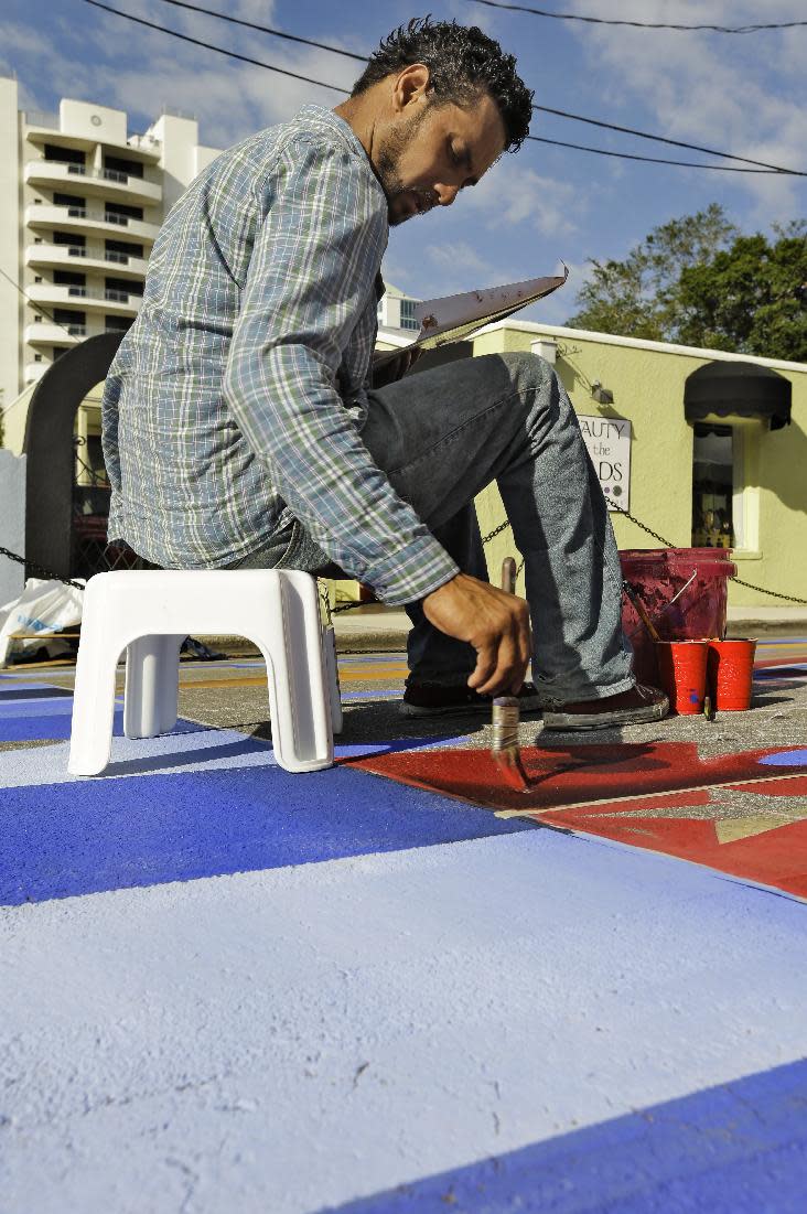 Agnaldo Eduardo Kobra, of Brazil, works on his 3D pavement art during the Sarasota Chalf Festival Wednesday, Oct. 31, 2012, in Sarasota, Fla. The annual festival begins this week and runs through Nov. 6.(AP Photo/Chris O'Meara)