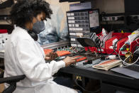 FILE - In this Wednesday, April 28, 2021 file photo, an employee manually assembles a circuit-board element before a ribbon-cutting ceremony to mark the opening of a Nanotronics manufacturing center at the Brooklyn Navy Yard in the Brooklyn borough of New York. Matthew Putman, CEO of Nanotronics, said he agonized over his decision to impose a vaccine mandate on his more than 100 employees, who have mostly been working onsite throughout the pandemic. As it turned out, nearly all of his workers were already vaccinated, though he dreads the prospect of having to fire any holdouts. (AP Photo/John Minchillo, Pool)