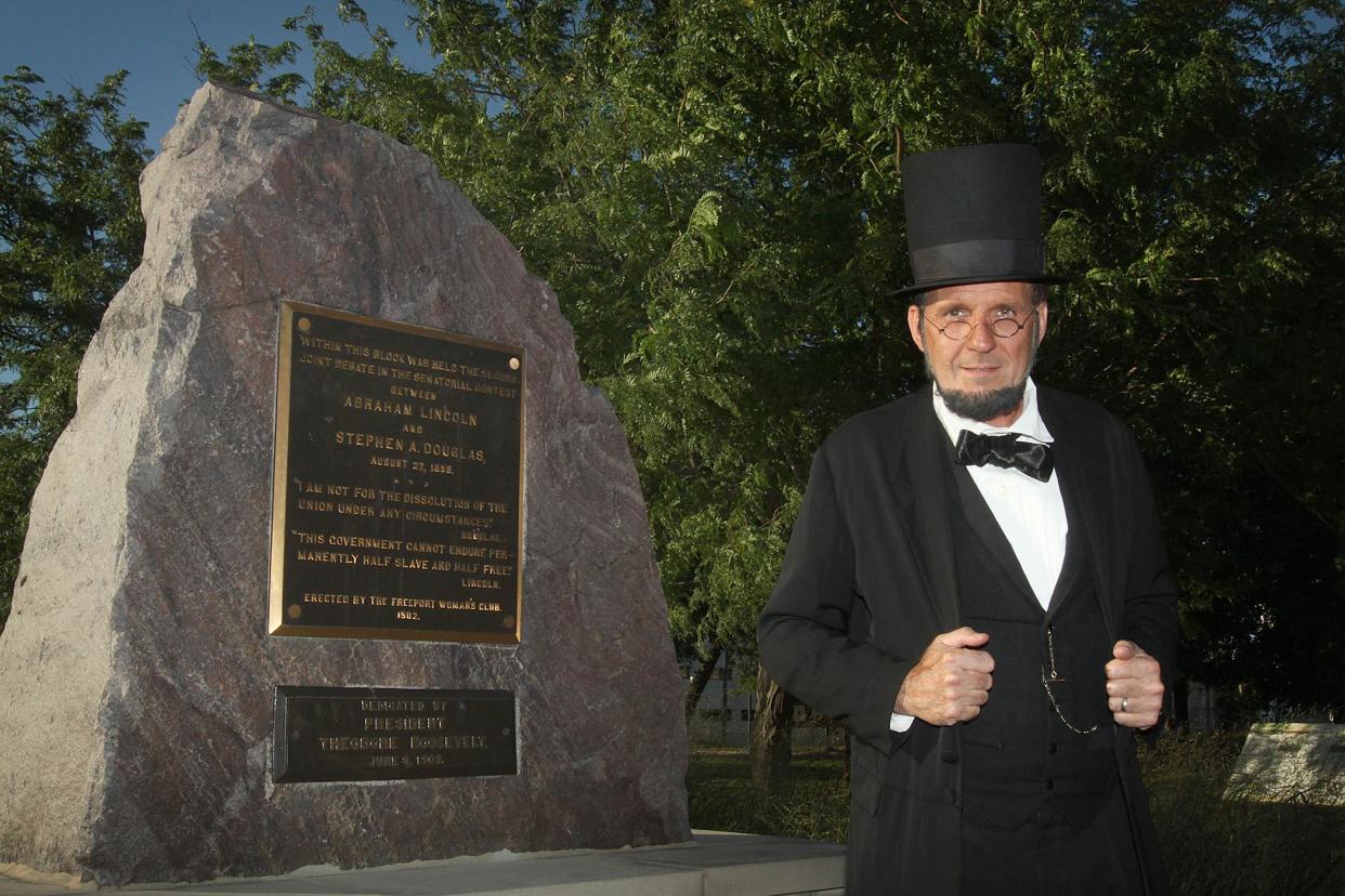 George Buss of Freeport, known for his portrayal of Abraham Lincoln, poses in 2015 next to the rock that commemorates Debate Square, the site of the Lincoln-Douglas Debates in Freeport. Buss, who that year was named as the permanent portrayer of Abraham Lincoln at Gettysburg National Military Park in Gettysburg, Pennsylvania, pleaded guilty to charges of child pornography on April 14, 2022.