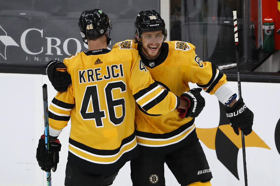 Boston Bruins David Krejci congratulates David Pastrnak after Pastrnak scored against the Pittsburgh Penguins during the second period of an NHL hockey game Saturday, April 3, 2021, in Boston. (AP Photo/Winslow Townson)