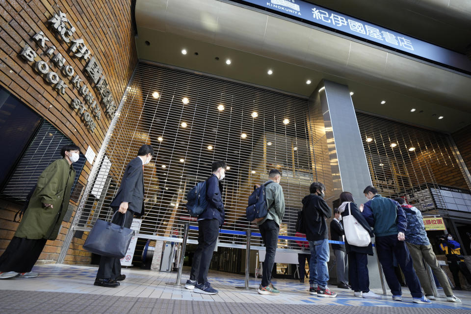 Customers queue up to buy Japanese writer Haruki Murakami's new novel "The City and Its Uncertain Walls" on the first day for sale at Kinokuniya bookstore in Shinjuku district early Thursday, April 13, 2023, in Tokyo. Murakami wrote a story of a walled city when he was fresh off his debut. More than four decades later, as a seasoned and acclaimed novelist, he gave it a new life as “The City and Its Uncertain Walls.”(AP Photo/Eugene Hoshiko)