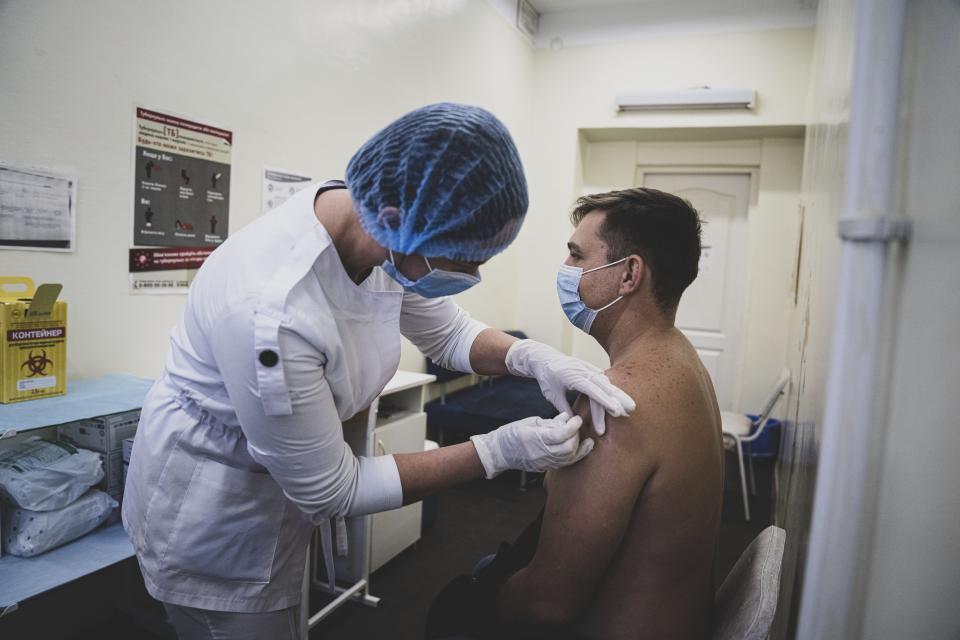 In this handout photo released by UNICEF, Vitaliy Romanov receives a shot of a vaccine against coronavirus in Kharkiv, Ukraine, on Saturday, Oct. 16, 2021. Ukraine is suffering through a surge in coronavirus infections, along with other parts of Eastern Europe and Russia. While vaccines are plentiful, there is a widespread reluctance to get them in many countries — though notable exceptions include the Baltic nations, Poland, the Czech Republic, Slovenia and Hungary. (Evgeniy Maloletka/UNICEF via AP)