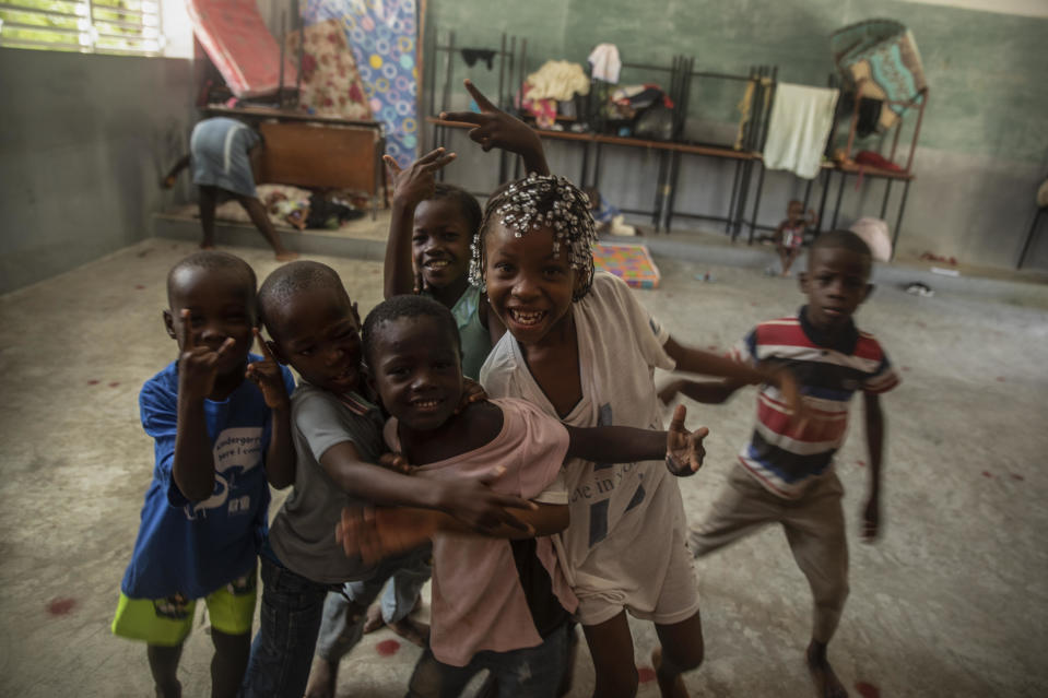 Children forced to leave their homes in Cite Soleil due to clashes between armed gangs, react to a visiting photographer at a school turned into a makeshift shelter in Port-au-Prince, Haiti, Saturday, July 23, 2022. (AP Photo/Odelyn Joseph)
