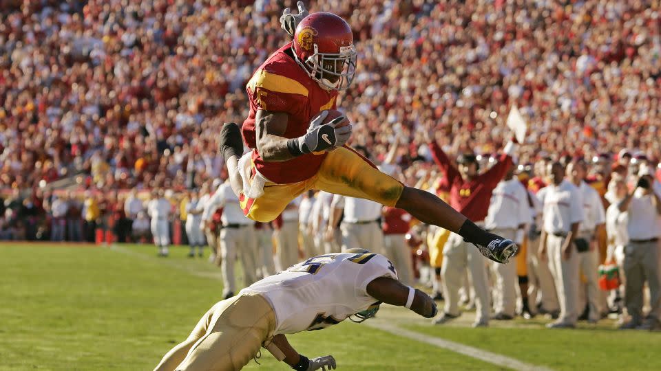 Bush leaps over UCLA defender Marcus Cassel during his time as a USC Trojan at the Los Angeles Memorial Coliseum, December 3, 2005. - Chris Carlson/AP