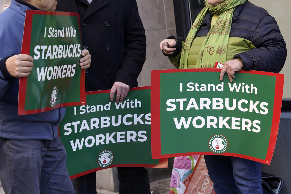 Three people hold signs supporting Starbucks workers gather outside a Starbucks on New York's Upper West Side, Thursday, Nov. 16, 2023. Thousands of workers at more than 200 U.S. Starbucks stores plan to walk off the job Thursday in what organizers say is the largest strike yet in the two-year-old effort to unionize the company's stores. (AP Photo/Richard Drew)