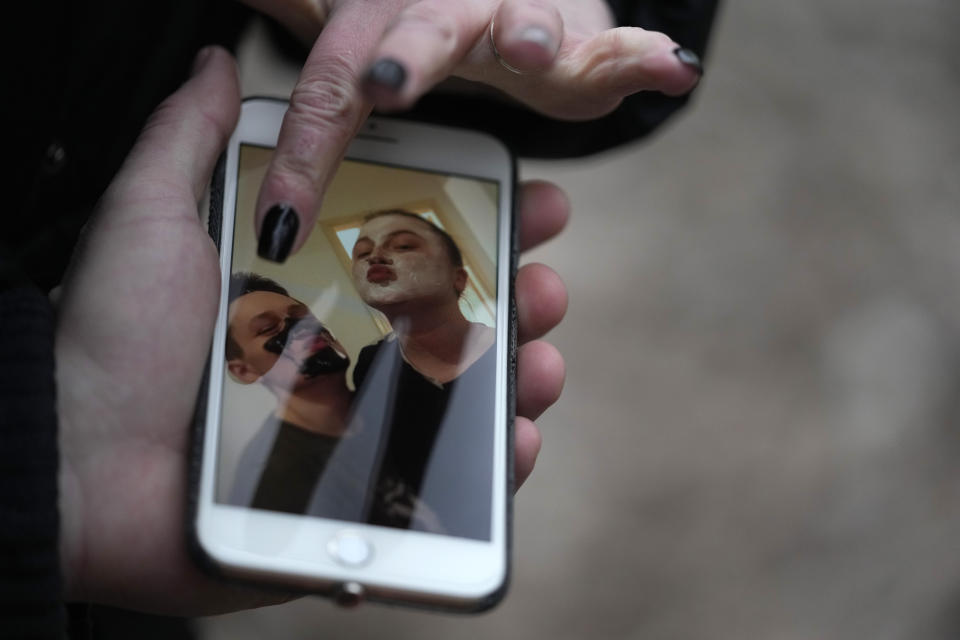 Mariia Vyhivska, from Ukraine, and Iurii Kurochkin, from Russia, show their photos on a mobile phone, in Belgrade, Serbia, Sunday, Feb. 5, 2023. Vyhivska and Kurochkin fell in love before Russia invaded Ukraine, while playing an online video game. To get together, they had to leave their homes and defy hatred generated by war. An estimated 200,000 Russians and some 20,000 Ukrainians have come to Serbia in the past year. (AP Photo/Darko Vojinovic)