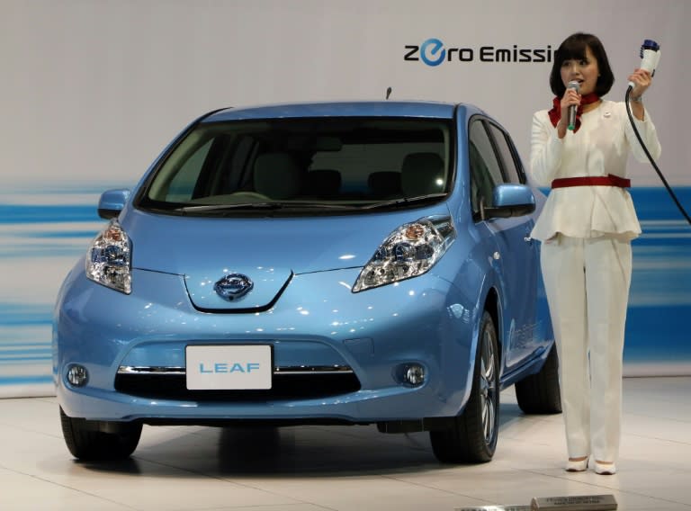 A Nissan Motor employee demonstrates how to charge the company's Leaf electric car at the company's showroom in Yokohama on February 9, 2015