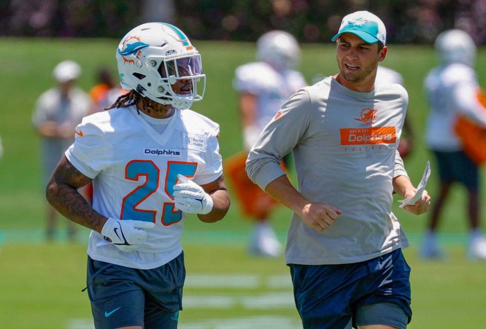 Miami Dolphins Jaylen Wright (25) runs with offensive assistant Max McCaffrey during practice.