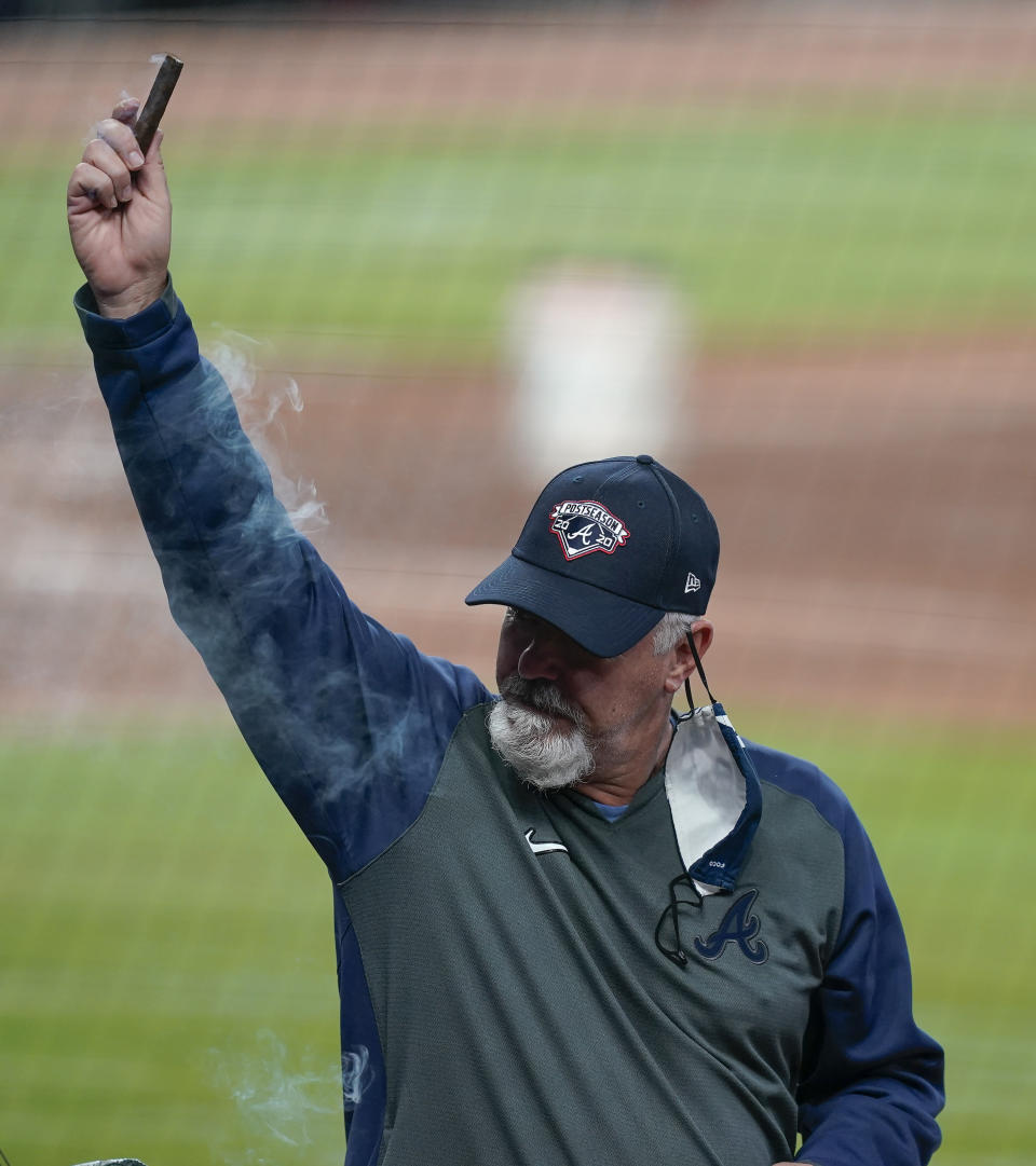 The Atlanta Braves pitching coach Rick Kranitz lights a cigar in celebration after a baseball game to clinch the NL East title against the Miami Marlins on Tuesday, Sept. 22, 2020, in Atlanta. (AP Photo/Brynn Anderson)