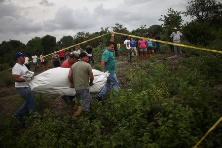 Forensic workers carry the body of a man who was killed in San Pedro Sula, Honduras, June 4, 2018. REUTERS/Edgard Garrido