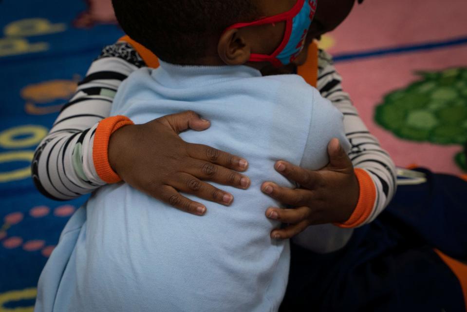 Toddlers share a hug during story time at Cribs 2 College Academy child care center in Detroit on Wednesday, April 5, 2023. 