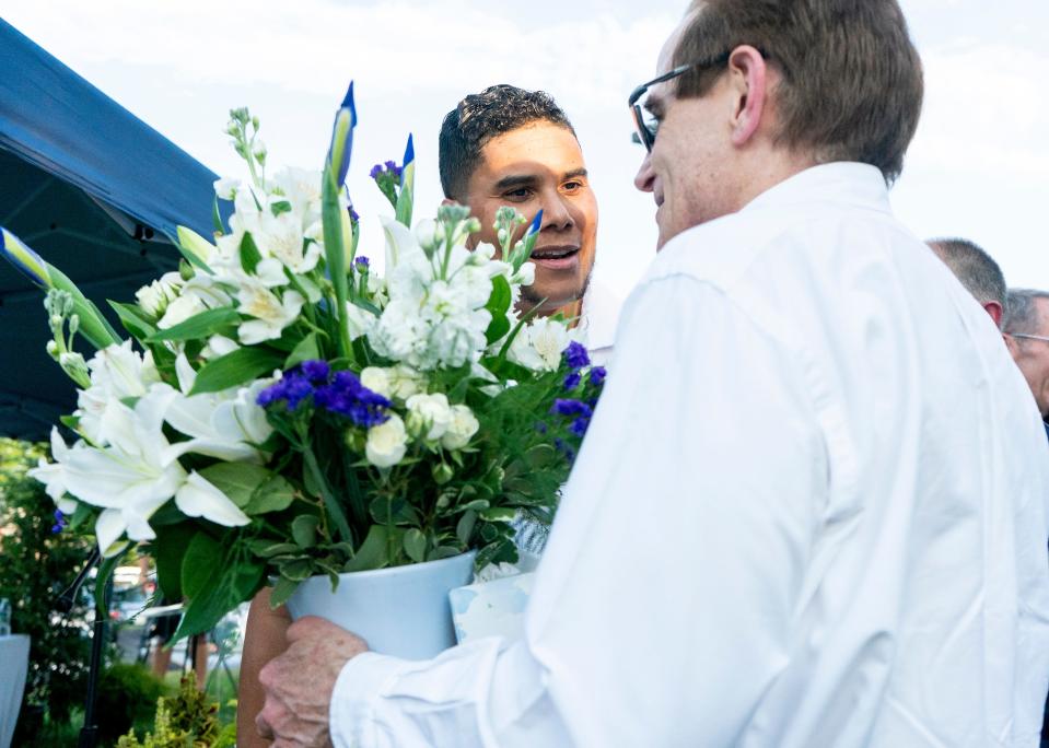 The Crossing's lead pastor George Matthew Clash, left, gives Dave Love, husband to Yuko Love, flowers in her honor after the memorial service for the 2023 fatal flood victims at The Crossing Church in Washington Crossing on Monday, July 15, 2024.
