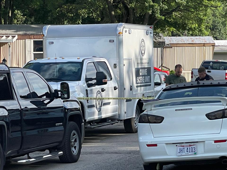 Investigators returned to the scene of a mobile home park in Clark County the day after a Clark County deputy was shot and later died from his injuries. A memorial outside the house has started to grow with two deputies arriving at the scene and placing flowers outside the house. (Gabrielle Enright/Staff)