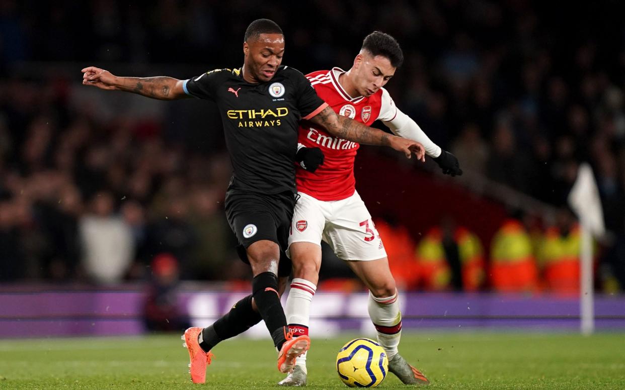 Manchester City's Raheem Sterling (left) and Arsenal's Gabriel Martinelli battle for the ball during the Premier League match at The Emirates Stadium, London - PA