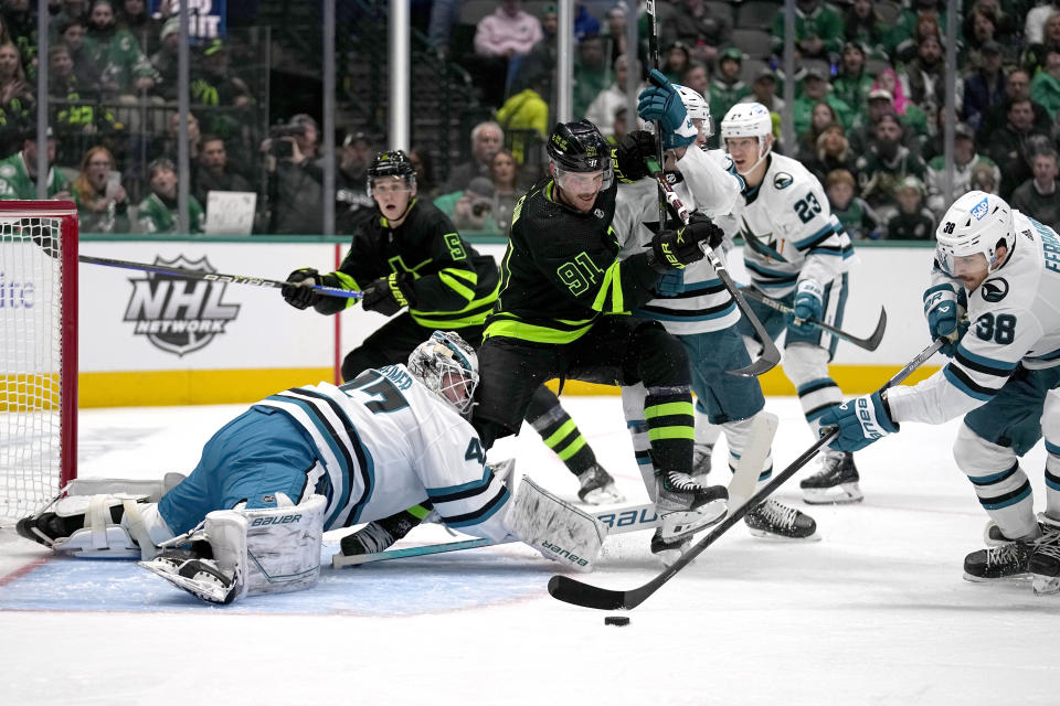 San Jose Sharks goaltender James Reimer (47) and defenseman Mario Ferraro (38) defend against pressure at the net from Dallas Stars center Tyler Seguin (91) in the first period of an NHL hockey game in Dallas, Friday, Nov. 11, 2022. (AP Photo/Tony Gutierrez)