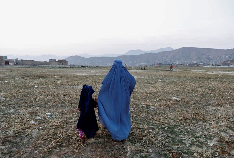 An Afghan woman clad in burqa walks in the early morning in Kabul, Afghanistan