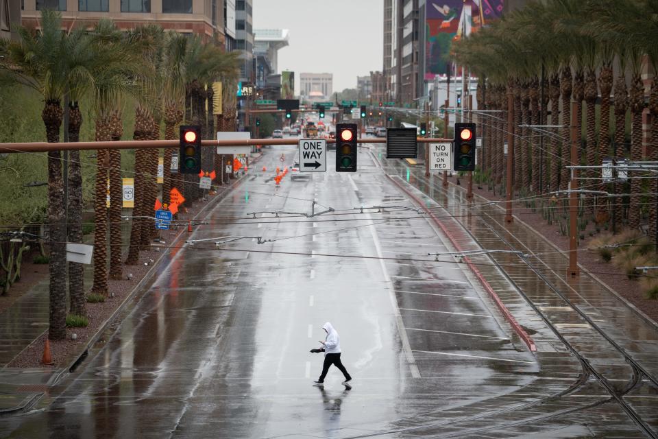 A pedestrian crosses Washington Street on March 15, 2023, in downtown Phoenix.