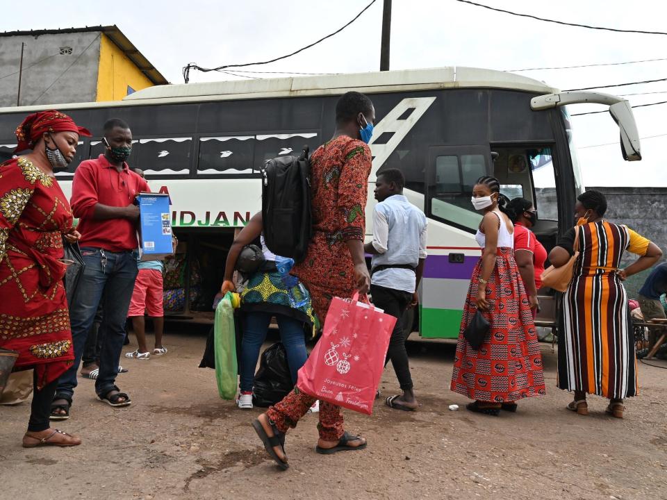 Passengers wearing face masks prepare to board a bus at the Adjame bus station in Abidjan on July 15, 2020, on the first day of the lifting of travel restrictions between Abidjan and cities of provinces following the outbreak of the COVID-19 coronavirus. (Photo by Issouf SANOGO / AFP) (Photo by ISSOUF SANOGO/AFP via Getty Images)