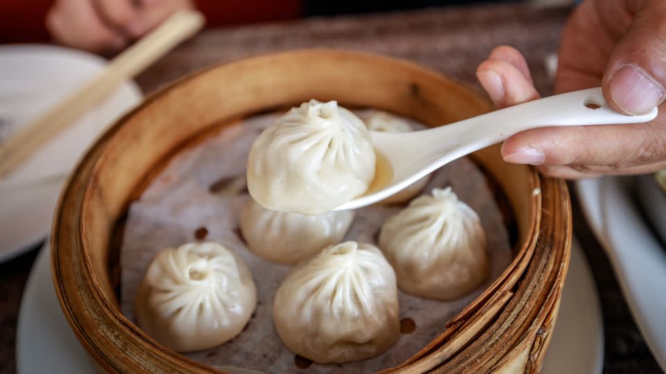 Use a spoon to catch the spilled soup from a xiaolongbao. - yooranpark/Adobe Stock