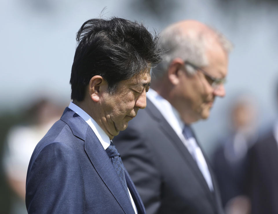 Japanese Prime Minister Shinzo Abe, observes a silent prayer after laying a wreath along with Australian Prime Minister Scott Morrison, right, at the Cenotaph War Memorial in Darwin, Australia, Friday, Nov. 16, 2018. (Glenn Campbell/Pool Photo via AP)