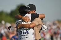 Xander Schauffele hugs his caddie Austin Kaiser after winning the final round of the PGA Championship golf tournament at the Valhalla Golf Club, Sunday, May 19, 2024, in Louisville, Ky. (AP Photo/Jon Cherry)