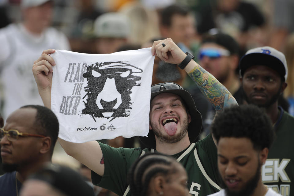 A fan holds up a towel during a parade celebrating the Milwaukee Bucks' NBA Championship Thursday, July 22, 2021, in Milwaukee. (AP Photo/Aaron Gash)