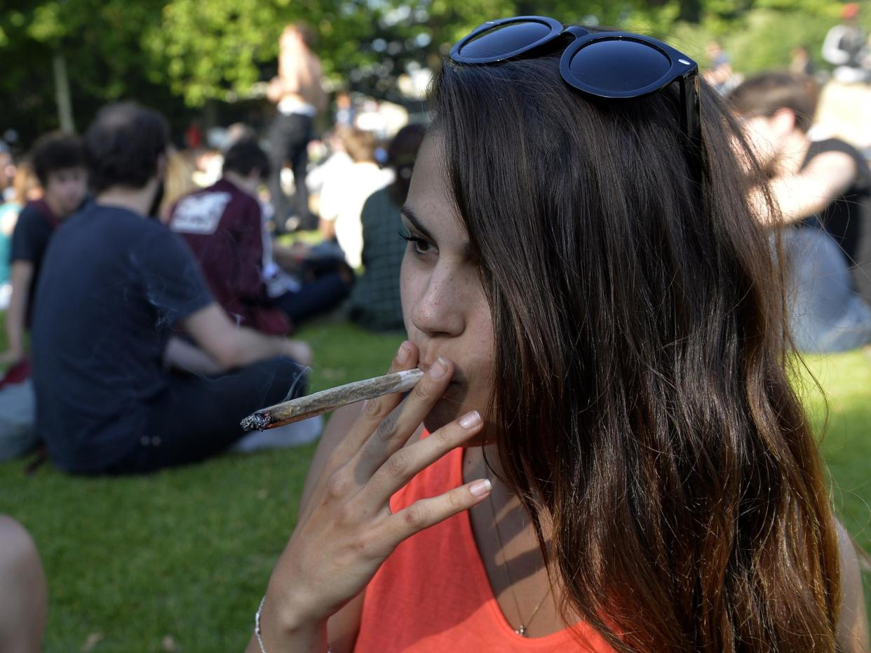 A woman smokes a joint during a 2014 demonstration in Paris calling for the legalisation of cannabis: Getty Images