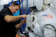 NASA Commercial Crew Astronaut Josh Cassada adjusts the length of an arm during a space suit fitting session at the Johnson Space Center in Houston