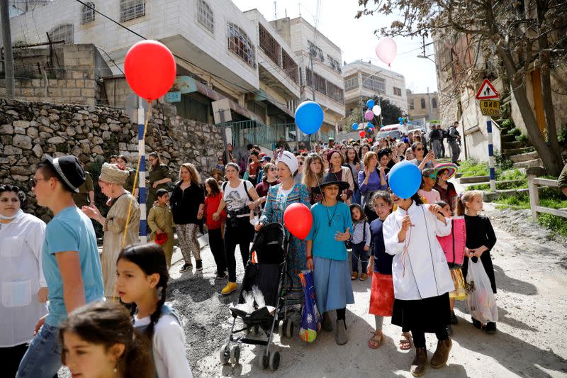 FILE PHOTO: Israeli settlers, some dressed up in costumes, take part in celebrations marking the Jewish holiday of Purim, in the Israeli-occupied West Bank city of Hebron