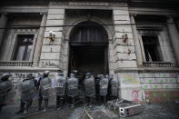 La policía rodea el edificio del Congreso después de que los manifestantes le prendieran fuego, en la ciudad de Guatemala, el sábado 21 de noviembre de 2020. Cientos de manifestantes protestaban en varias partes del país el sábado contra el presidente guatemalteco Alejandro Giammattei y miembros del Congreso por la aprobación del presupuesto 2021 que redujo fondos para educación, salud y lucha por los derechos humanos. (Foto AP/Moisés Castillo)