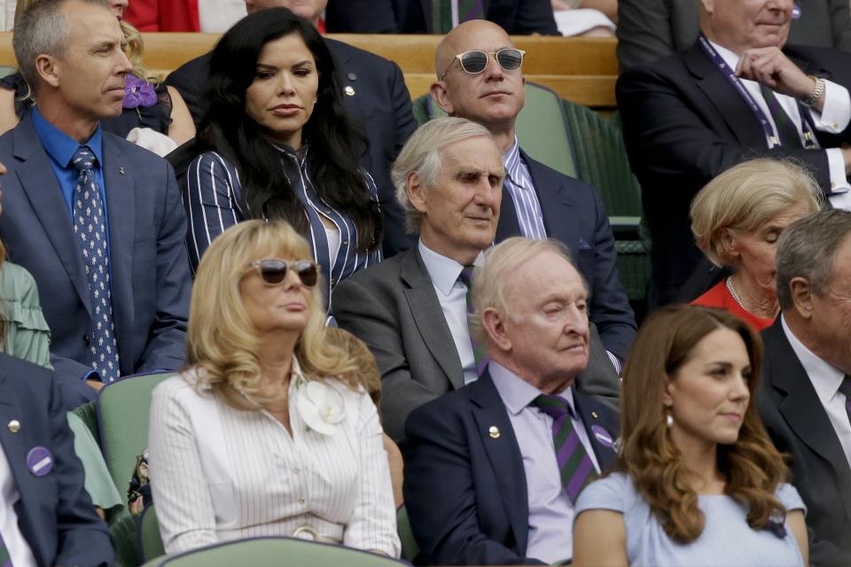 Amazon founder Jeff Bezos, top and third from left, and Lauren Sanchez, top and second from left, sit in the Royal Box on Centre Court to watch the men's singles final match of the Wimbledon Tennis Championships in London, Sunday, July 14, 2019. (AP Photo/Tim Ireland)