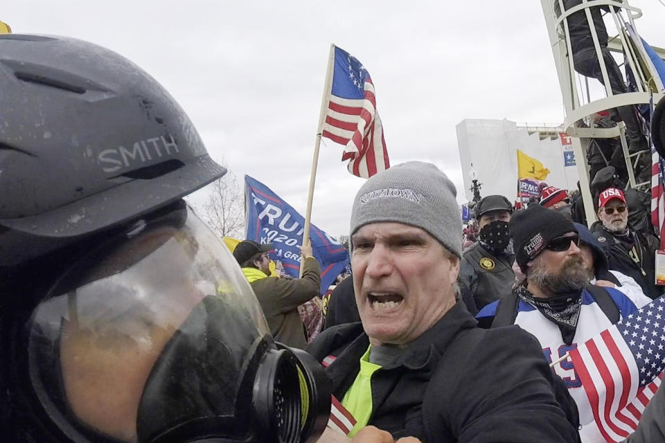 In this Jan. 6, 2021, image from video, Alan William Byerly, center, is seen allegedly attacking an Associated Press photographer during a riot at the U.S. Capitol in Washington. Byerly has been arrested on charges that he assaulted an Associated Press photographer and police officers. (AP Photo/Julio Cortez)