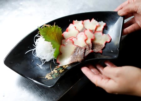 Yoko Ichihara prepares whale bacon at the kitchen of her restaurant named P-man in Minamiboso