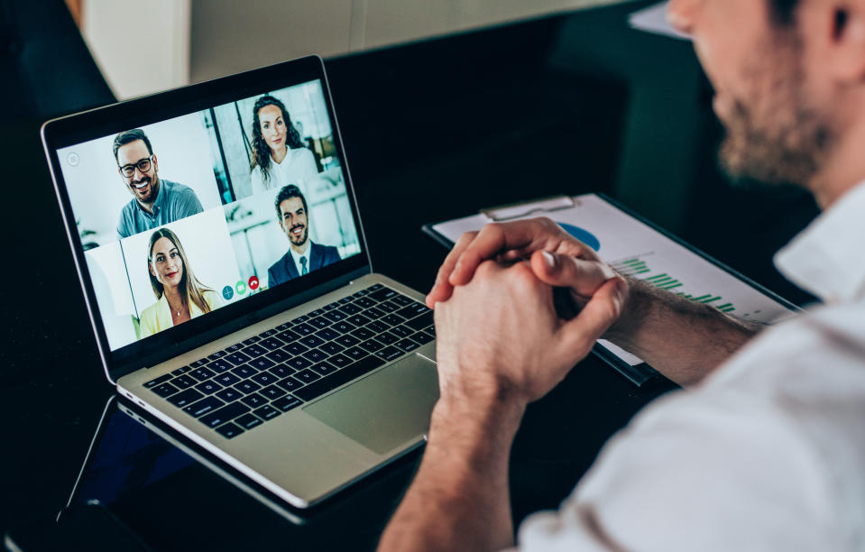 Businessman talking to his colleagues about business plan in video conference. Corporate business team using laptop for a online meeting in video call. Young man working at home. Shot of unrecognizable businessman using a laptop for web conference.