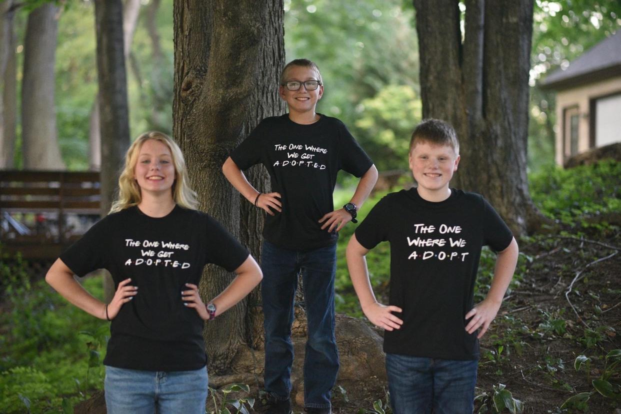 From left to right: Charlotte Passamoni, 13, Alec Passamoni, 12, and Coltyn Feld, 13. Shane and Jessica Passamoni adopted Alec and Charlotte in September 2022; Coltyn is Shane and Jessica's biological son. Charlotte and Alec wear T-shirts reading, "THE ONE WHERE WE GET ADOPTED." Coltyn's T-shirt reads, "THE ONE WHERE WE ADOPT."