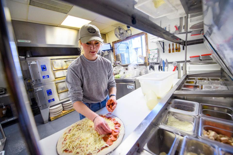 Kate McComas makes a pizza Wednesday while working at Switchyard Brewing Co. on North Walnut Street.