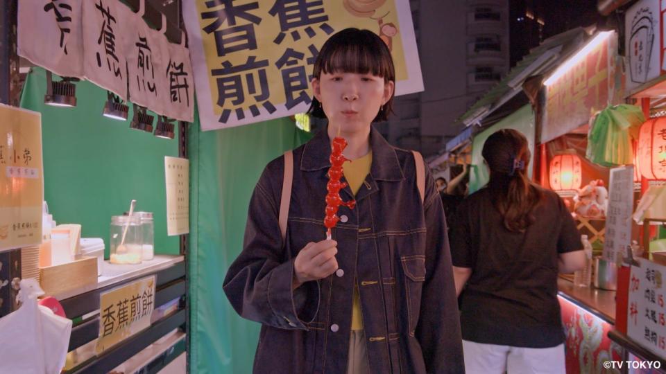 江口德子主演日劇《獨活女子的守則》第四季來台拍攝，她在夜市品嚐糖葫蘆。（Hami Video提供）