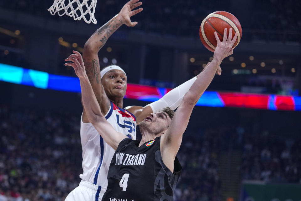 U.S. forward Paolo Banchero (8) goes up to block the3 shot of New Zealand guard Taylor Britt (4) during the first half of a Basketball World Cup group C match in Manila, Saturday, Aug. 26, 2023. (AP Photo/Michael Conroy)