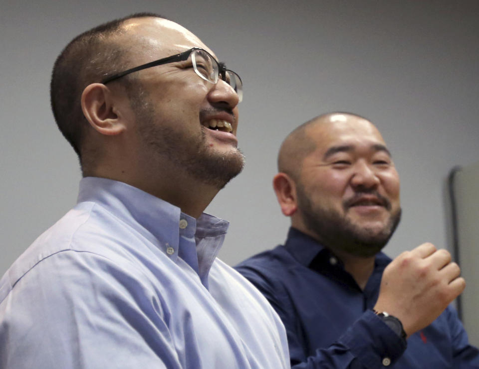 In this Jan. 28, 2019, photo, Kenji Aiba, left, and his partner Ken Kozumi laugh during an interview with The Associated Press in Tokyo. Kozumi and Aiba have held onto a marriage certificate they signed at their wedding party in 2013, anticipating that Japan would emulate other advanced nations and legalize same-sex unions. That day has yet to come, and legally they are just friends even though they've lived as a married couple for more than five years. On Thursday, Feb. 14, 2019, Valentine’s Day, the couple is joining a dozen other same-sex couples in Japan’s first lawsuits challenging the constitutionality of the country’s rejection of same-sex marriage. (AP Photo/Toru Takahashi)