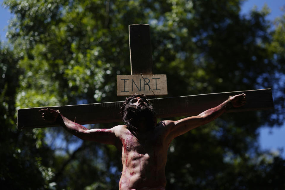 An actor, playing the role of Jesus Christ, hangs on a cross during a Way of the Cross reenactment, as part of Holy Week celebrations, in Atyra, Paraguay, Friday, March 29, 2024. Holy Week commemorates the last week of Jesus' earthly life which culminates with his crucifixion on Good Friday and his resurrection on Easter Sunday. (AP Photo/Jorge Saenz)